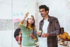 A man and woman planning with post-it notes