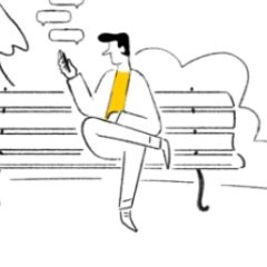 A man sat on a bench whilst texting